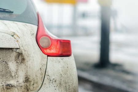 The back side of cars in the mud on the road. Stop and open the light brake with the turn indicator.の写真素材