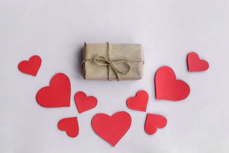 Valentine's Day background. Red hearts and a gift on the background top view.