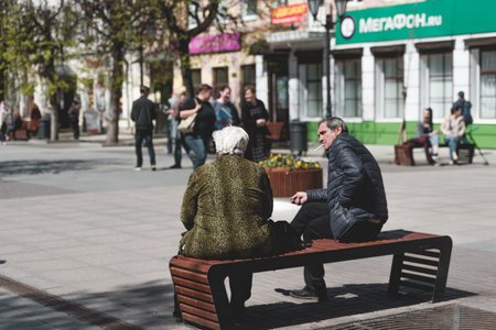 Russia, Gatchina, May 2022: people are resting on a bench in the city square during the dayのeditorial素材