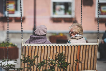 Elderly women on a swing to relax in the city. Russia, Gatchina, May 2022.のeditorial素材