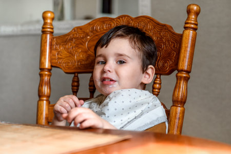 little boy at the table face in foodの写真素材