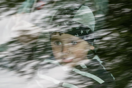 The face of a small child in the reflection of a car windowの写真素材