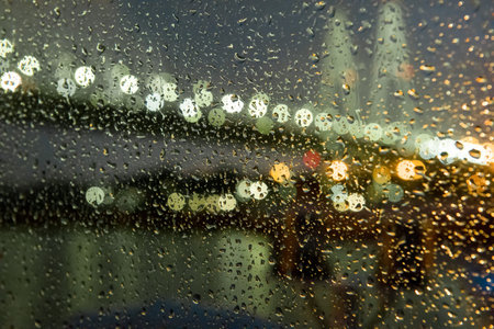 View through wet glass on the night lights of the embankmentの写真素材