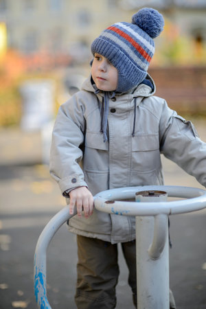 A three-year-old boy rides a swing on the playgroundの写真素材