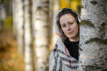 A young woman in a headscarf in an autumn parkの写真素材