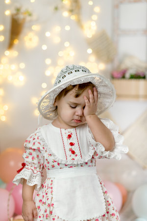 A little beautiful girl in a doll dress and a hatの写真素材