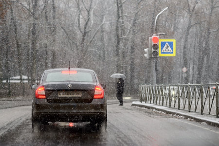 The first winter snow in the city and cars on the roadの写真素材