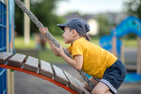 Little boy playing on a rope at a playgroundの写真素材