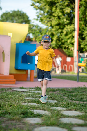 Little boy in a yellow T-shirt and cap on the playgroundの写真素材