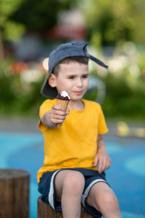 Little boy holding ice cream in hand - focus on ice creamの写真素材