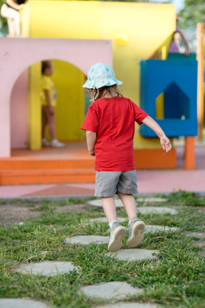 Little happy girl jumping on the playground in summer.の写真素材