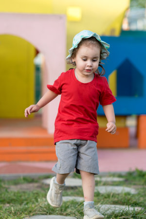 Little happy girl playing on the playground in summer.の写真素材