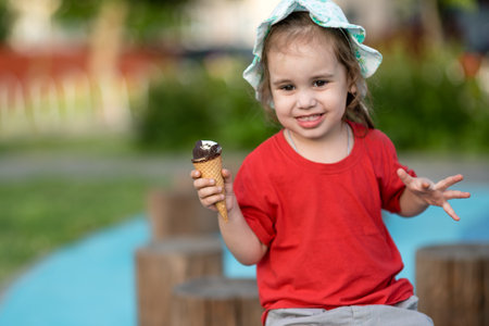 Adorable little girl with ice cream cone in the park on summer dayの写真素材