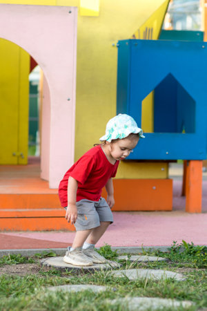 Little happy girl jumping on the playground in summer.の写真素材
