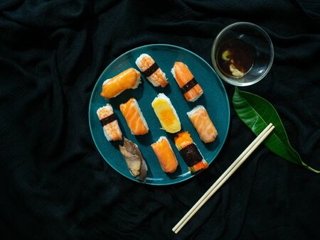 Sushi set on dish with Shrimp Sweet egg Salmon Crab stick Saba, Japanese food is good health, Color black background, Black cloth foundationの写真素材