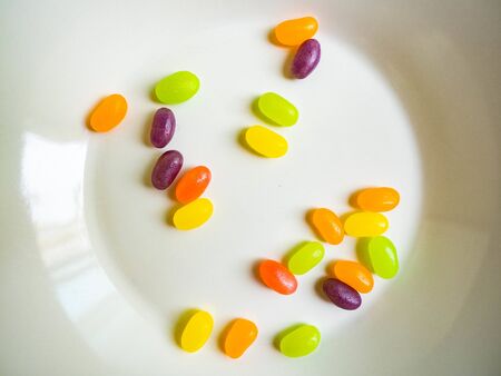 Candy Multicolored orange, green, purple, pink, yellow with a sour, fruity scent on a white dish.の写真素材