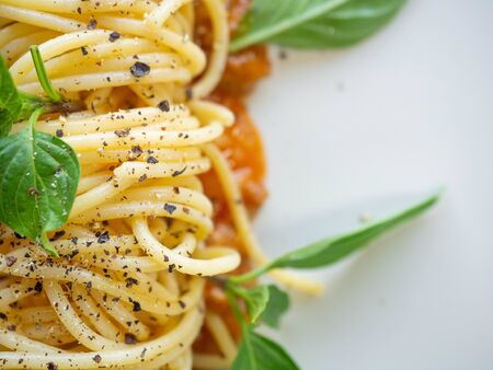 Spaghetti with tomato sauce,Ingredients Tomatoes,Minced pork,Garlic,Pepper,Basil,Is Italian food Placed on a white plateの写真素材