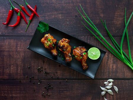 BBQ Chicken Legs with lime Topped with Spring onion,Chili,Garlic, Pepper,Barbecue sauce as an...
