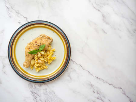 Garlic Butter Chicken with Pasta Main ingredient Garlic,Butter,Chicken,Pasta is placed on a white plate,Face with basil,White backgroundの写真素材