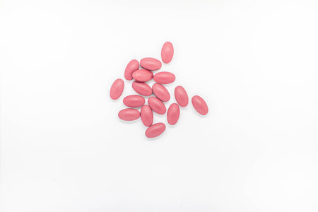 Red tablets Placed on white background Medicines help keep the body normal.
