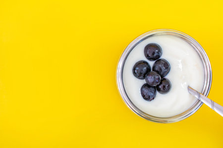 Natural flavor white yogurt in stainless steel cups and stainless steel spoons. Topping with grapes Fruits with a sweet and sour taste.
Yellow backgroundの写真素材