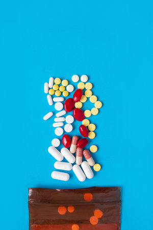 A pill that is poured out of the medicine bag There are many types of drugs used to treat various diseases. Blue backgroundの写真素材
