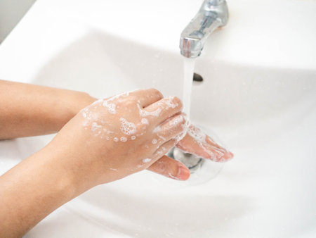 A woman cleaning hands Use hand soap until white bubbles form in the basin.