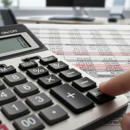 Closeup of a hand using calculator to calculate numbers on a financial reportの素材