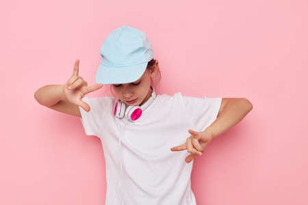 Portrait of happy smiling child girl wearing headphones posing emotions Lifestyle unaltered