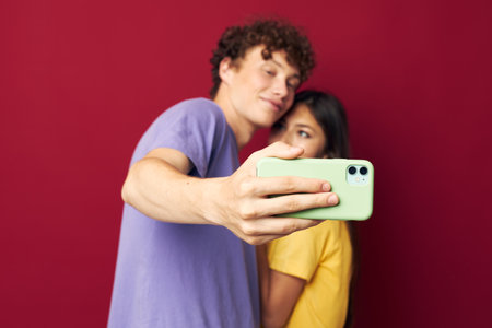 Man and woman in colorful T-shirts with a phone Youth styleの写真素材