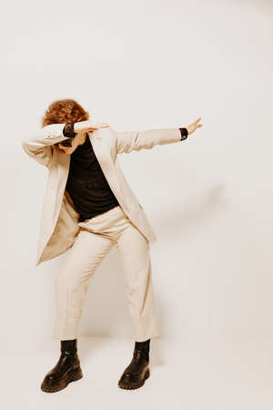beautiful woman in a suit sunglasses gestures with his hands emotions light background unalteredの写真素材