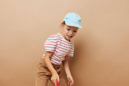 pretty young girl skateboard in hand posing baby clothes fun isolated backgroundの写真素材