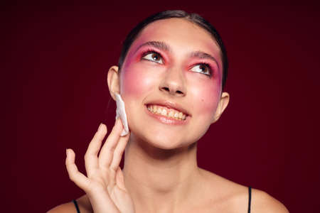 Beauty fashion female pink face makeup posing attractive look skin care pink background unalteredの写真素材