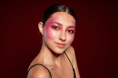 Young beautiful woman smile makeup attractive look pink background unalteredの写真素材