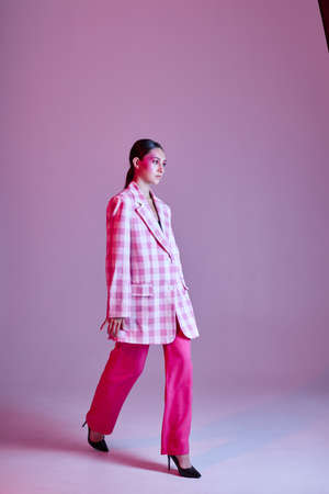 Young beautiful woman style clothing fashion posing modern style pink background unalteredの写真素材