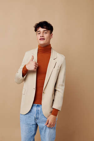 handsome guy in a beige jacket talking on the phone isolated background unalteredの写真素材