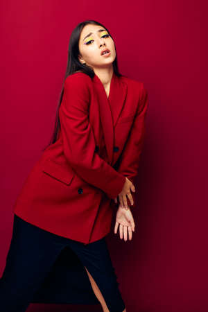 young woman fashion posing in red jacket red background unalteredの写真素材