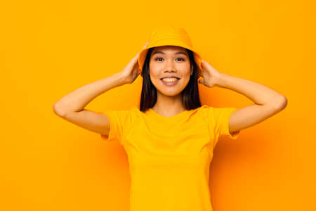 woman with Asian appearance in a yellow t-shirt and hat posing emotions Monochrome shotの写真素材