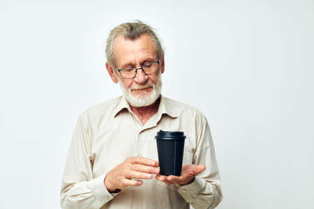 Portrait of happy senior man in a shirt and glasses a black glass cropped viewの写真素材