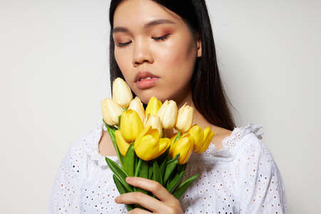 woman with a bouquet of flowers smile close-up light background unalteredの写真素材