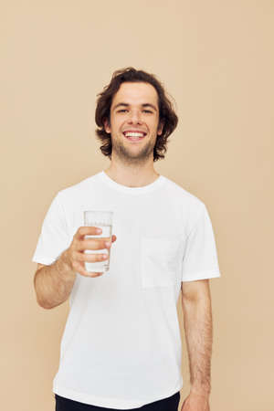 Cheerful man glass of water in his hands emotions posing isolated backgroundの写真素材
