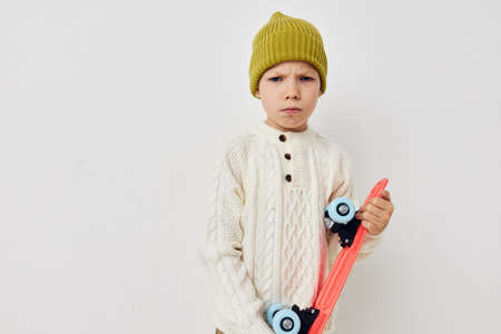 Portrait of happy smiling child girl posing skateboard entertainment light background