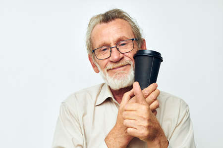 Senior grey-haired man with a gray beard in a shirt and glasses cropped viewの写真素材