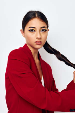 portrait pretty woman fashion posing in red jacket with a long pigtail studio model unaltered