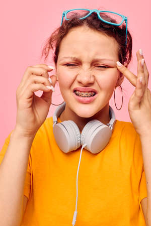 portrait of a young woman wearing headphones blue glasses close-up emotions cropped view unalteredの写真素材