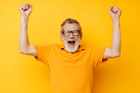 Portrait elderly man wearing glasses yellow shirt posing monochrome shotの写真素材