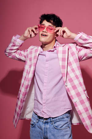 portrait of a young man self confidence pink plaid blazer fashion posing pink background unalteredの写真素材