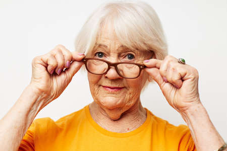 elderly woman in casual t-shirt and glasses light backgroundの写真素材