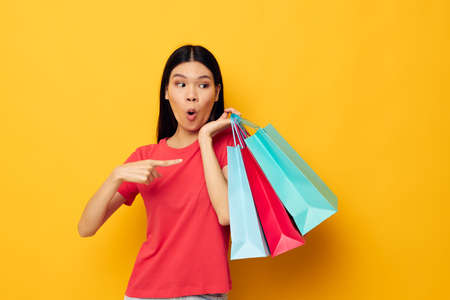 Charming young Asian woman with colorful bags posing shopping fun Lifestyle unaltered