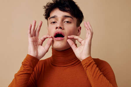 handsome guy stylish hairstyle brown turtleneck light background unaltered